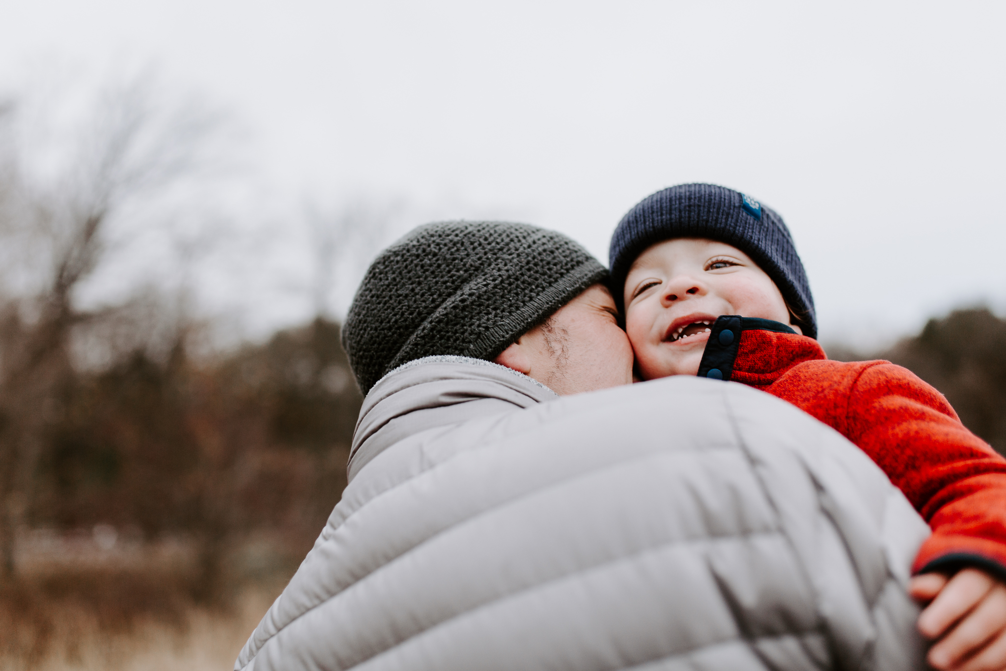 Father kissing his young boy in his arms.